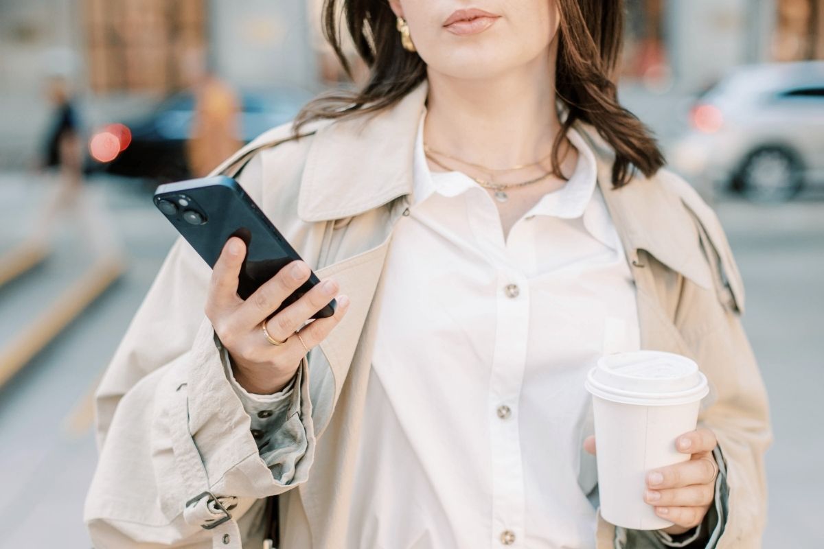 スマホを手に持って歩く女性