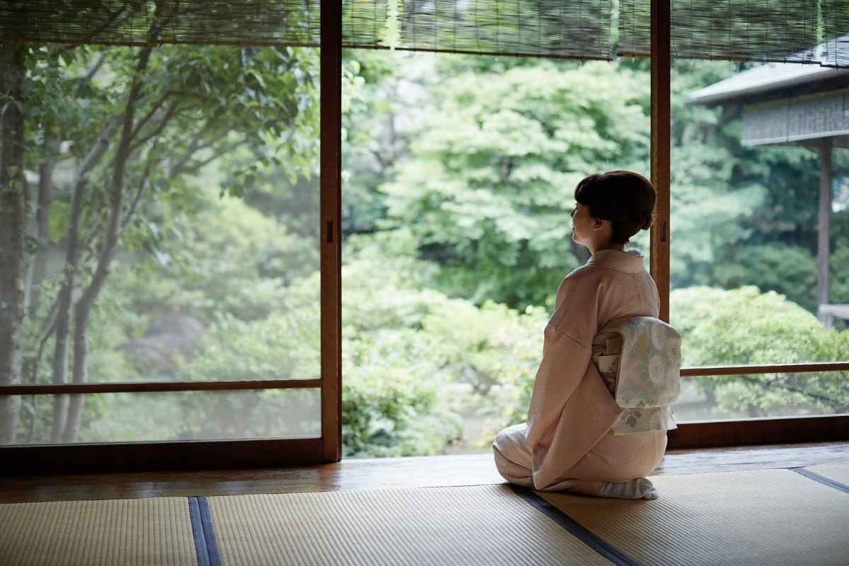 窓の外の緑を眺める和服の女性