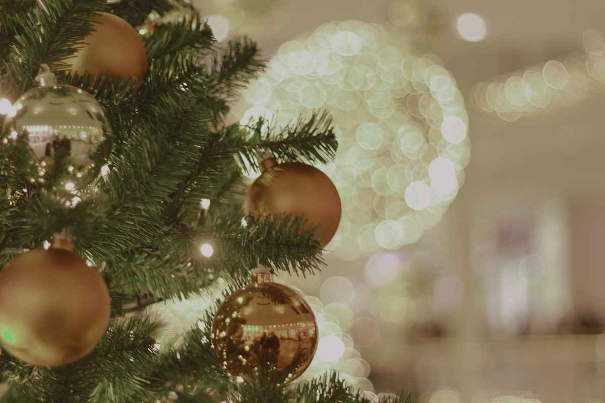 ゴールドのクリスマスオーナメントが飾られたツリーと温かなイルミネーション