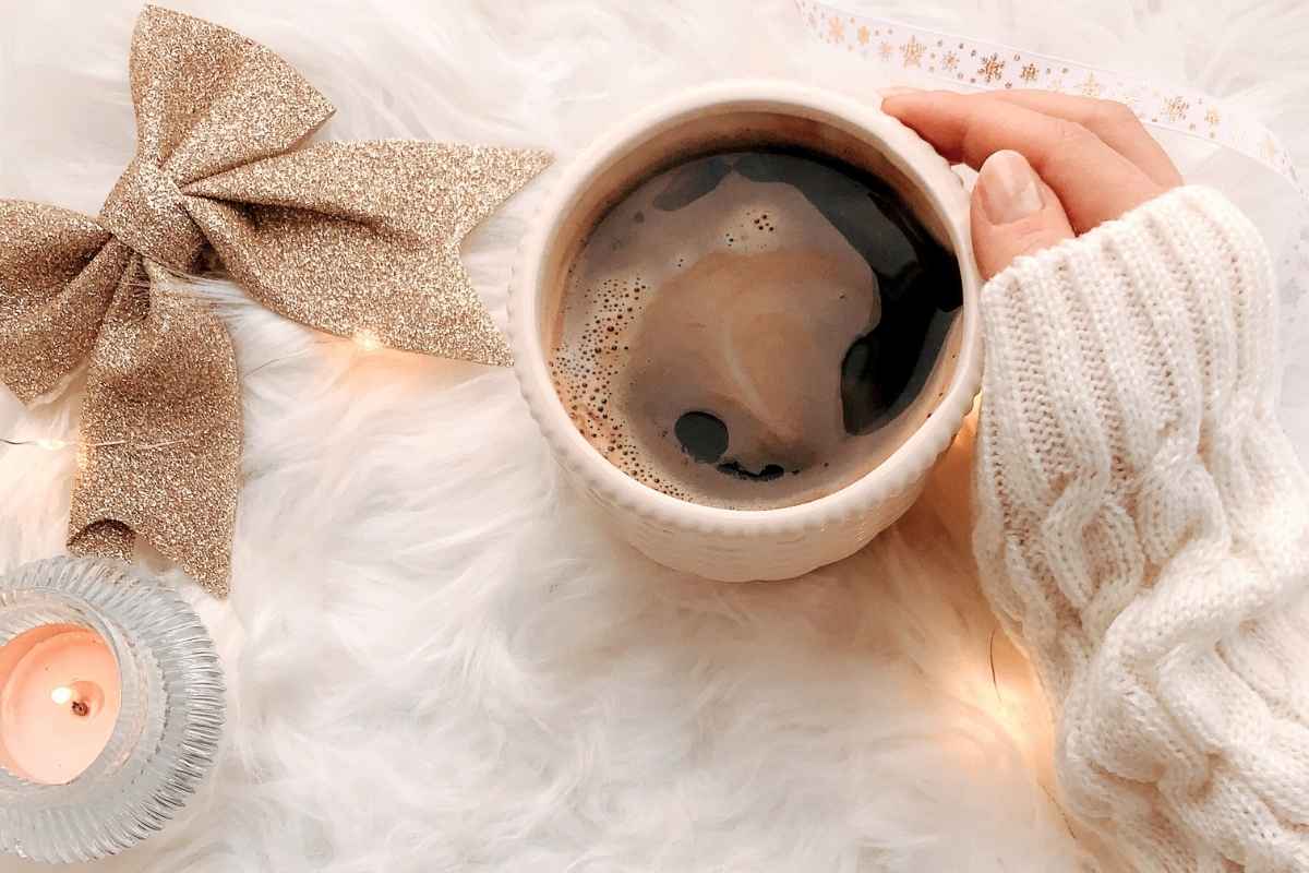 暖かな室内でコーヒーに添えた女性の手元